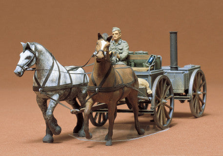Model of a horse-drawn German field kitchen with two horses and a figure on a brown background