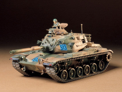 Model tank with camouflage paint job on a brown surface