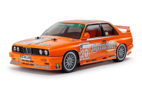 Model car of an orange BMW with sponsor logos on a white background