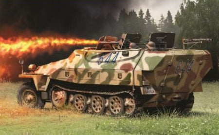 A German military armoured vehicle with a green, brown, and tan camouflage pattern is shown in a grassy field with a forest in the background. The vehicle is emitting a bright orange fire or explosion effect from its side, with smoke and dark trees behind it.