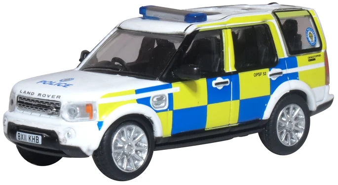 Model of a police Land Rover vehicle with white, yellow, and blue colors on a white background