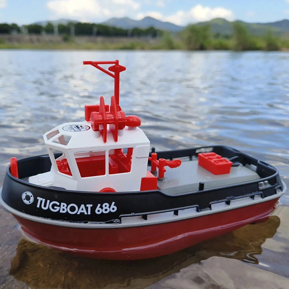 RC Model tugboat on a body of water with mountains in the background