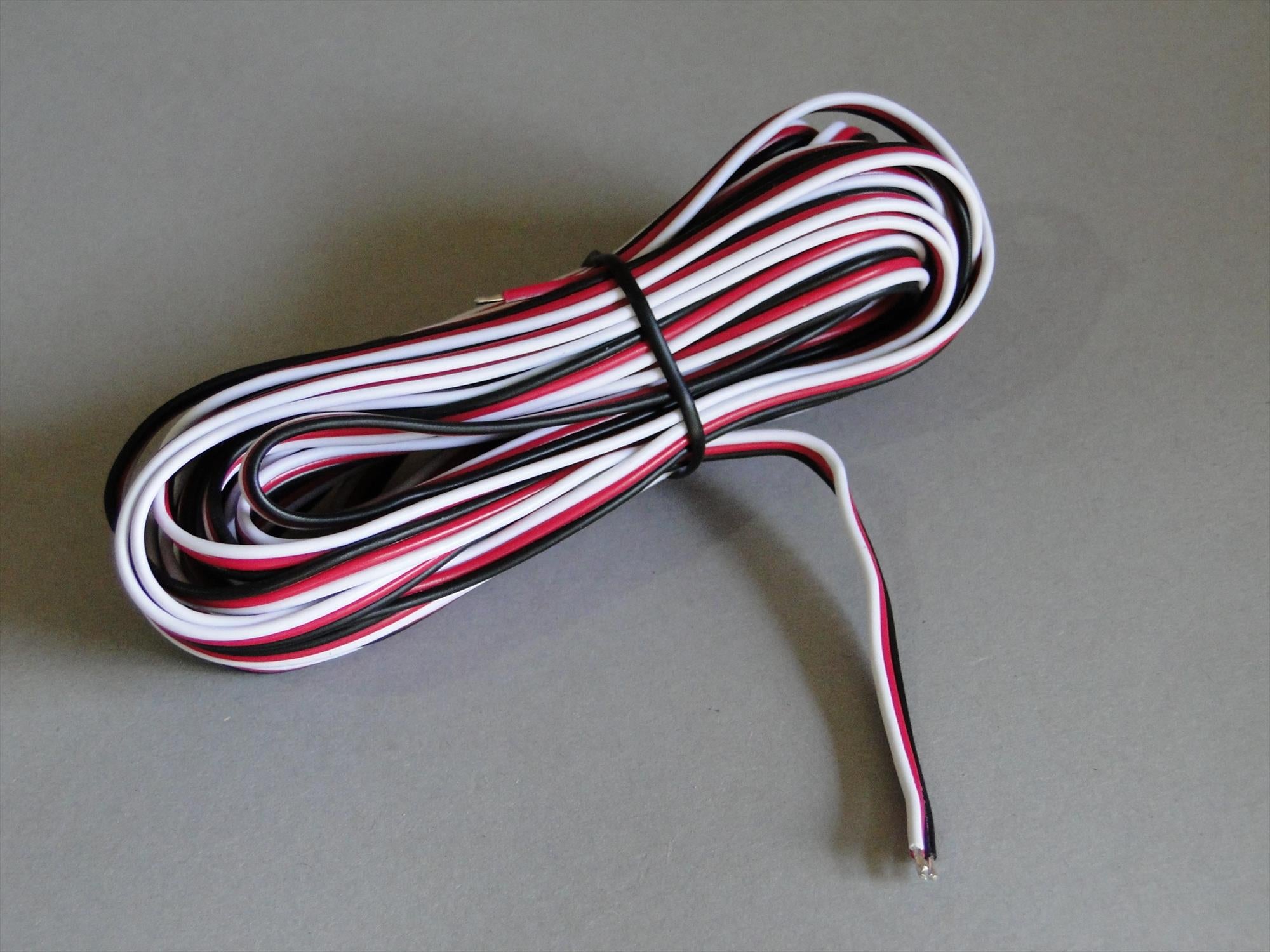 A coiled bundle of Futaba Heavy Duty Wire with red, white, and black strands, secured with a black rubber band, on a plain grey background.