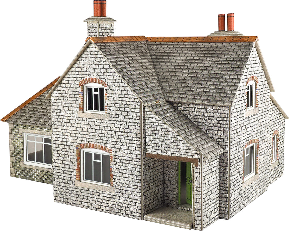 Model of a two-story house with brick facade and tiled roof on a white background