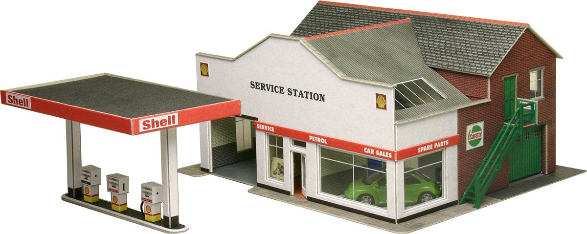 Model of a Shell service station with a red roof and white walls.