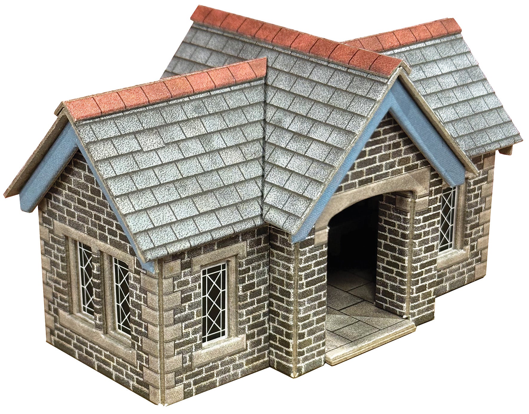 A miniature model of a stone Station Shelter with grey shingled roofs, red tiled ridge caps, and blue painted gable accents, shown on a plain white background.
