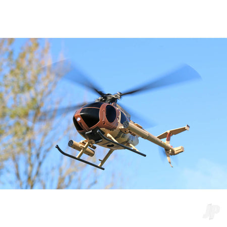 Model Helicopter flying against a clear blue sky with trees in the background