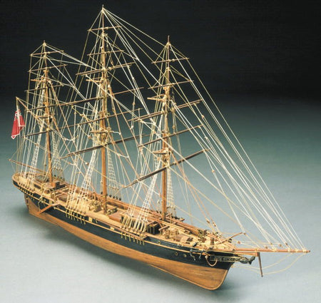 Model of a three-masted sailing ship on a grey background