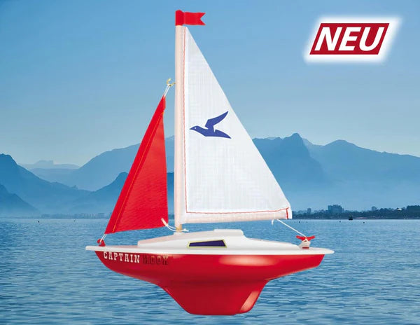 Red and white sailboat on water with mountains in the background and 'NEU' label.